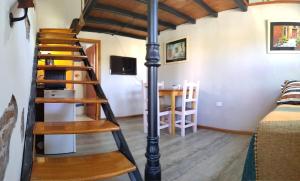 uma escada em espiral num quarto com uma cama e uma mesa em The Rustic Hause 2 em Gualeguay