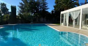una piscina con acqua blu di fronte a una casa di B&B Villa Adriana ad Andria