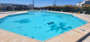 une grande piscine d'eau bleue dans l'établissement Appartement marina hammamet, à Hammamet