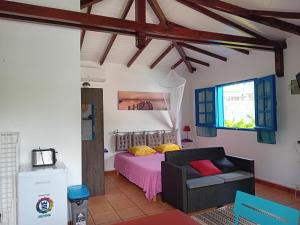 a bedroom with a bed and a couch and a window at Idéal pour séjour professionnel ou touristique in Baie-Mahault