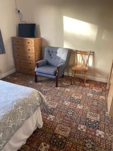 1 dormitorio con cama, silla y vestidor en Country House 20 minutes to Galway City en Kilcolgan