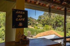 un panneau indiquant le café aarea do sur une table dans l'établissement Hostel Yellow House MG, à Itamonte