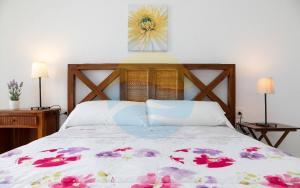 a bedroom with a bed with a flower picture on the wall at Baconer - Casa en l'Ampolla con jardín privado y acceso directo al mar - Deltavacaciones in L'Ampolla