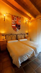 1 dormitorio con 2 camas y una bandera en la pared en LAS CALLEJUELAS, en Atienza