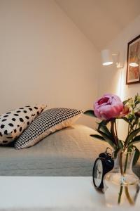 a bed with two pillows and a vase with a flower at Äspögården Bed & Breakfast in Klagstorp