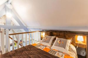 Un dormitorio con una cama con almohadas. en Le Pont de Benneville en Cahagnes