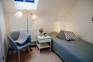 una camera da letto con un letto con una sedia e una lampada di Äspögården Bed & Breakfast a Klagstorp
