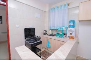 a small kitchen with a stove and a window at LaMeg furnished 1 bedroom Garden Estate in Nairobi