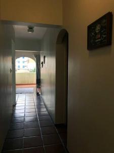um corredor com piso em azulejo e uma porta aberta em Apartamento muito charmoso na praia da Enseada no Guarujá