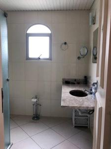 uma casa de banho com um lavatório e uma janela em Apartamento muito charmoso na praia da Enseada no Guarujá