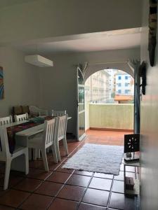 uma sala de jantar com mesa e cadeiras e uma varanda em Apartamento muito charmoso na praia da Enseada no Guarujá