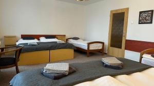 2 posti letto in una camera con 2 sedie e 2 letti di Hotel Pod Vlekem a Loučná pod Klínovcem