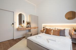 布達佩斯的住宿－You Boutique Suites, Best Location by BQA，卧室配有一张白色大床和镜子