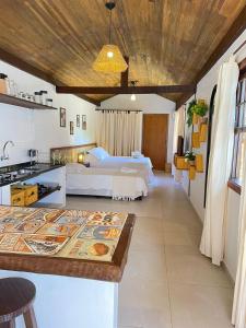 a hotel room with two beds and a kitchen at Villa Tiê Paraty in Paraty