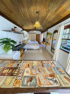 een kamer met een bed en een keuken met een tafel bij Villa Tiê Paraty in Paraty