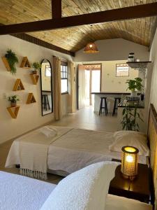 a bedroom with a large bed and a table at Villa Tiê Paraty in Paraty