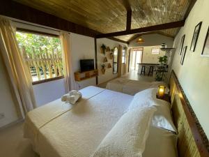 een slaapkamer met een bed met een teddybeer erop bij Villa Tiê Paraty in Paraty