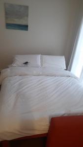 een wit bed met witte kussens en een raam bij Apartamento turísticos Puente Romano P1 1-C in Salamanca