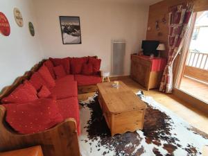 a living room with a red couch and a table at Appartement Crest-Voland, 3 pièces, 6 personnes - FR-1-733-122 in Crest-Voland