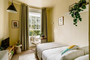 1 dormitorio con cama y ventana en Mason & Fifth, Primrose Hill, en Londres
