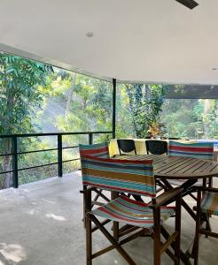 una mesa de madera y sillas en un balcón con vistas en Balai Benedicere Bed & Breakfast, en Bacnotan