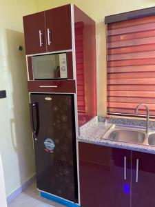 una piccola cucina con frigorifero e lavandino di MOK Apartments & Suites a Lagos