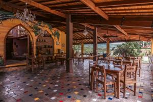 uma sala de jantar com mesas e cadeiras de madeira em Pousada do Capão Chapada Diamantina em Vale do Capão