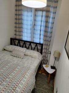 1 dormitorio con 1 cama, 1 lámpara y 2 ventanas en vista al mar Habitacion en apartamento compartido, en Moraira