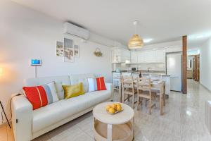 een woonkamer met een witte bank en een tafel bij Petite Homes Beach in El Médano
