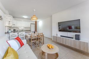 een woonkamer met een witte bank en een keuken bij Petite Homes Beach in El Médano