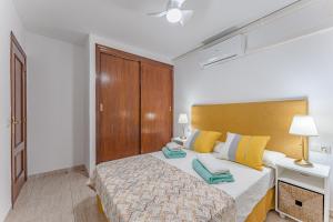 een slaapkamer met een bed met gele en blauwe kussens bij Petite Homes Beach in El Médano