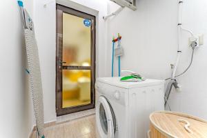 een wasmachine in de badkamer met een spiegel bij Petite Homes Beach in El Médano +6 foto's