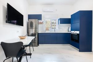 a kitchen with blue cabinets and a table and chairs at Moroccan style apartment near Bahai Gardens in Haifa