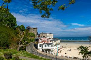 a building on the beach next to a beach at VTF L'Hotel Des Bains in Saint-Cast-le-Guildo