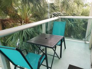 una mesa y sillas en un balcón con palmeras en Stunning Beach Apartment by Miami Te Esperaa - HOLLYWOOD 3V, en Hollywood