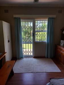 a bedroom with a door open to a yard at Shady Glade in Hillcrest +19 photos