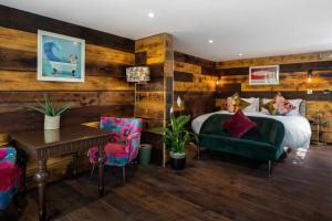 1 dormitorio con 1 cama, mesa y sillas en Limestone Hotel, en Lulworth Cove