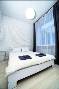 a white bed in a room with a large window at Atlas Hotel in Poltava