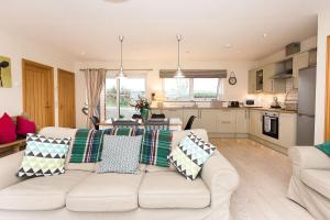 a living room with a white couch and a kitchen at Galloway View in Castle Douglas