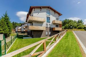 a house on a hill with a wooden fence at KORZO LIPNO C in Lipno nad Vltavou