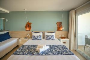 a hotel room with two beds and a window at Pousada Dona Moça in Morro de São Paulo