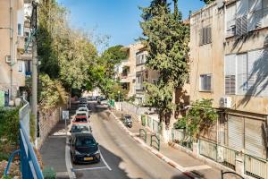 a city street with cars parked on the road at Moroccan style apartment near Bahai Gardens in Haifa