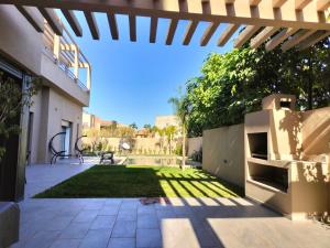 un cortile con patio e prato di Marrakech Villa du Golfeur familles uniquement a Marrakech