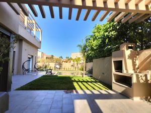 a backyard with a patio with a lawn at Marrakech Villa du Golfeur familles uniquement in Marrakesh