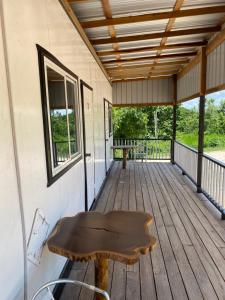 a wooden porch with a bench on a deck at Tropical View in Spanish Lookout