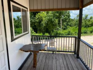 a wooden porch with a bench and a chair at Tropical View in Spanish Lookout