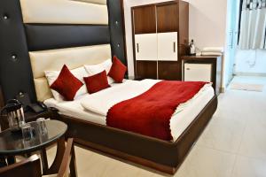 1 dormitorio con 1 cama grande con almohadas rojas en Hotel Sun International, en Nueva Delhi