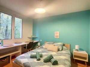 um quarto azul com uma cama e uma secretária. em Les Goujatoux chambre les Eyzies em Coursac