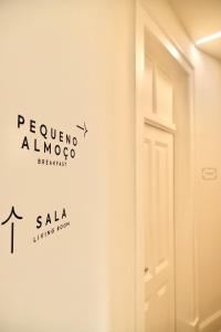 um quarto com uma porta e um sinal na parede em Vila Julieta Guesthouse em Coimbra