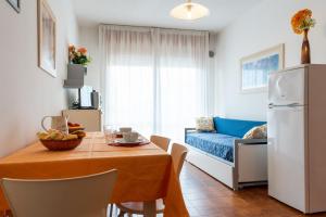 uma cozinha e sala de estar com uma mesa e um sofá em Residence Holiday em Porto Santa Margherita di Caorle